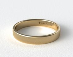 a yellow gold wedding ring on a white surface