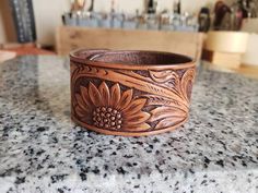 This is a handmade leather cuff bracelet with a tooled sunflower pattern. The cuff is stained briar brown, the edges are smoothed and finished, and the entire piece is coated with a clear protective sheen. The cuff has an antique copper snap for the closure. *Please measure your wrist before