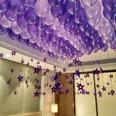 purple balloons and stars hanging from the ceiling