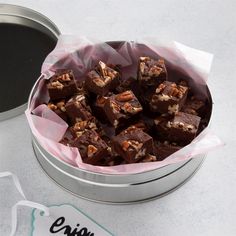 a tin filled with brownies sitting on top of a table