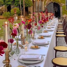 a long table is set up with flowers and candles for an outdoor dinner or party