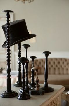 a table topped with black candlesticks and a top hat on top of it