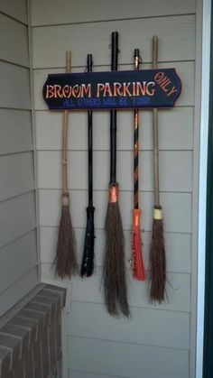 the brooms are hanging on the wall in front of the sign that says broom parking only