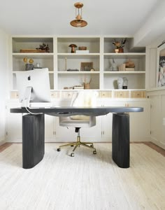 a home office with built - in bookcases and an l - shaped desk