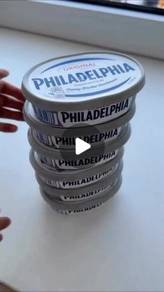 a stack of philadelphia ice cream sitting on top of a counter next to a window