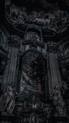 black and white photograph of the interior of an old church with statues on either side