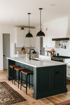 a kitchen with an island and stools in it