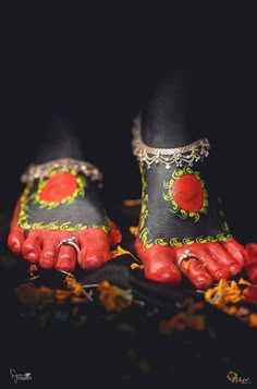 a pair of feet with red and green decorations on them