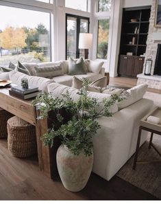 a living room filled with furniture and a large window covered in lots of natural light