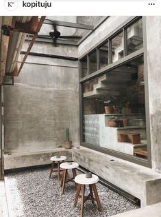 three small stools sit in front of a window on the outside of a building