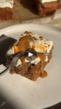 a piece of cake on a white plate with a fork and caramel drizzle