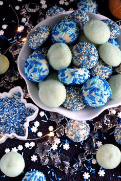 some blue and white desserts in a bowl on a table with snowflakes