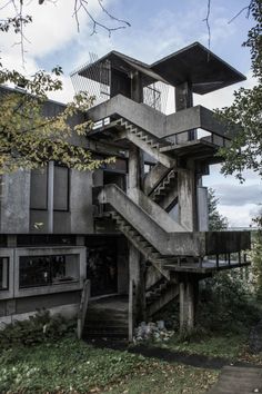 an old concrete building with stairs leading up to the top floor and second story windows