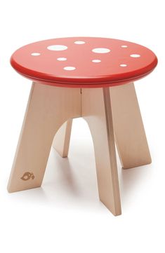 a wooden stool with red and white polka dots on the top, sitting in front of a white background