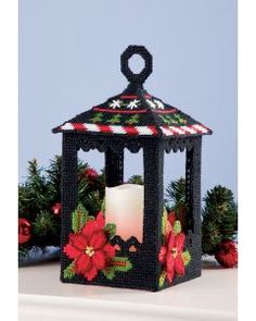 a small black candle holder decorated with poinsettis