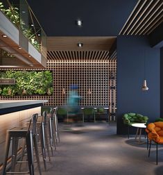 an empty bar with stools and green plants on the wall behind it at night