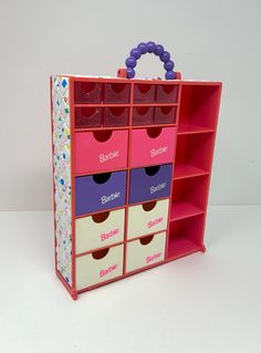 a pink and purple toy storage unit with six bins on each side, one for children's toys