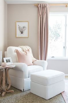 a white chair and ottoman in front of a window