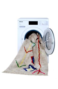 a white washing machine with a colorful towel on it