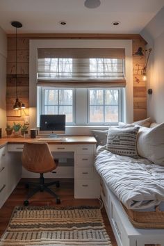 a bedroom with a bed, desk and computer on it in front of a window