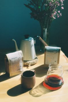 the table is set with two tea bags and a vase filled with flowers on it