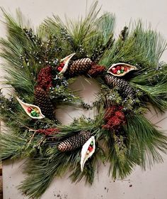 a christmas wreath with pine cones and berries