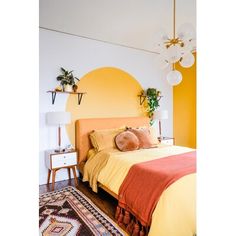 a bedroom with yellow walls and orange bedspread on the bed is decorated with potted plants