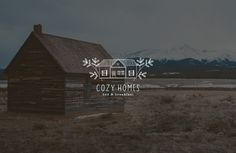 the logo for cozy homes is displayed in front of an old log cabin and snowy mountains