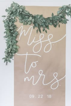 a sign that says miss to mrs with greenery on it and the words,