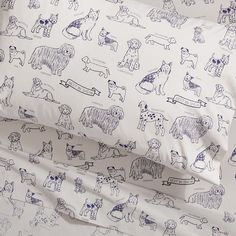 the bedding has dogs on it and is white with blue trimmings, along with two pillow cases