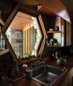 a kitchen sink under a large mirror next to a window