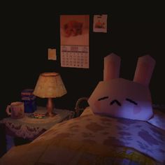 a bed room with a stuffed animal on it's side next to a lamp