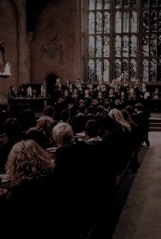 a large group of people sitting in front of a church pew with one person standing at the end