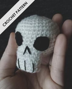 a crocheted skull is held in someone's hand