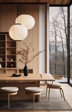 a dining room table with chairs and a vase on top of it next to a large window