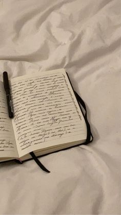 an open book with writing on it and a pen resting on the page next to it