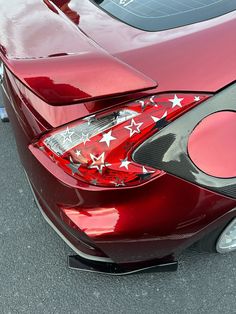 the rear end of a red sports car with stars painted on it