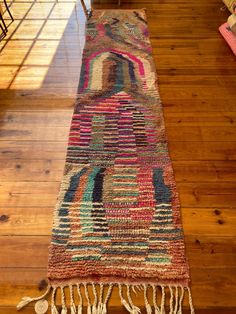 a multicolored rug with fringes on the floor