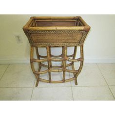 a bamboo planter sitting on top of a tile floor next to a white wall