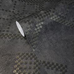 a white frisbee laying on top of a gray carpet covered in hexagonal tiles