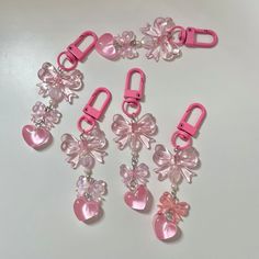 several pink and clear charms are attached to each other on a white surface with silver hardware