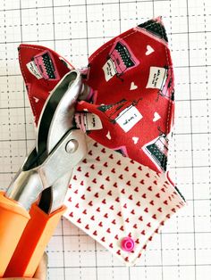 the scissors are being used to sew fabric on the top of the bow tie