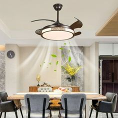 a dining room table with four chairs and a ceiling fan in the middle of it