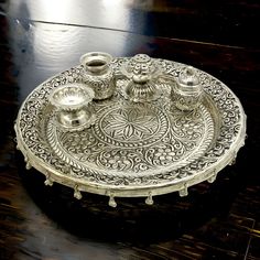 an ornate silver tray with three candles on the top and one candle holder in the middle