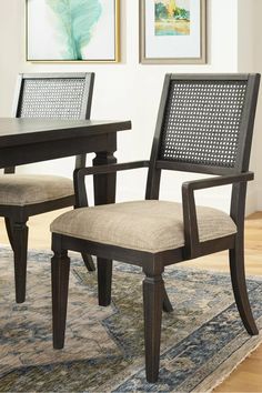 two chairs sitting on top of a rug in front of a wooden table and chair