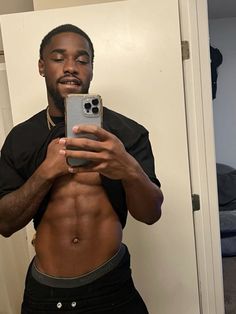 a man taking a selfie in front of a mirror with his cell phone up to his chest