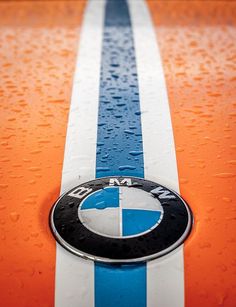 an orange and blue car with the bmw logo on it's front bumper strip