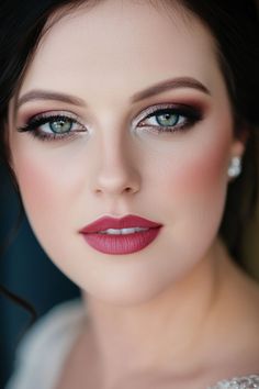 Woman with flawless makeup, defined eyebrows, and bold lipstick. Bride Makeup Dark Lips, Elegant Wedding Makeup Green Eyes, Smokey Eye Wedding Makeup Blue Eyes, Bride Makeup With Glasses, Classy Smokey Eye Makeup, Wedding Makeup Styles Brides, Red Hair Wedding Makeup, Bride Makeup Smokey Eye