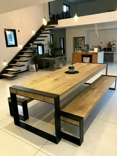 a wooden table sitting under a stair case