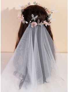 a bridal veil with flowers and leaves on the headpiece is shown in front of a white background